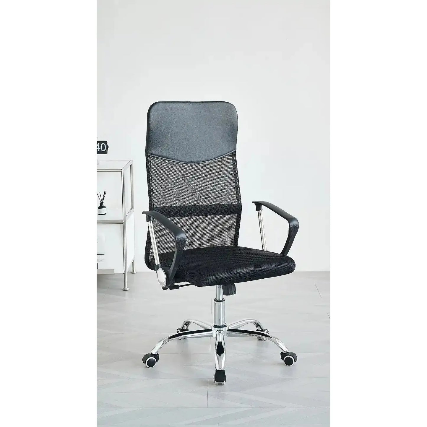 Black office chair with mesh backrest on a light wooden floor.