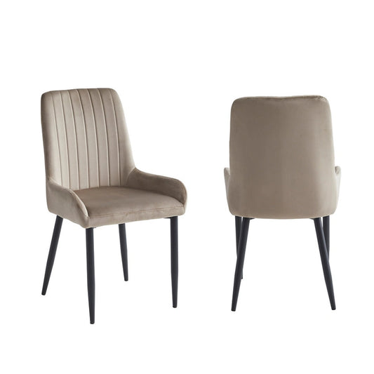 Two beige velvet dining chairs with black legs