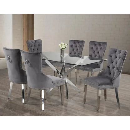 Dining room set with a glass table and grey tufted dining chairs on a wooden floor.