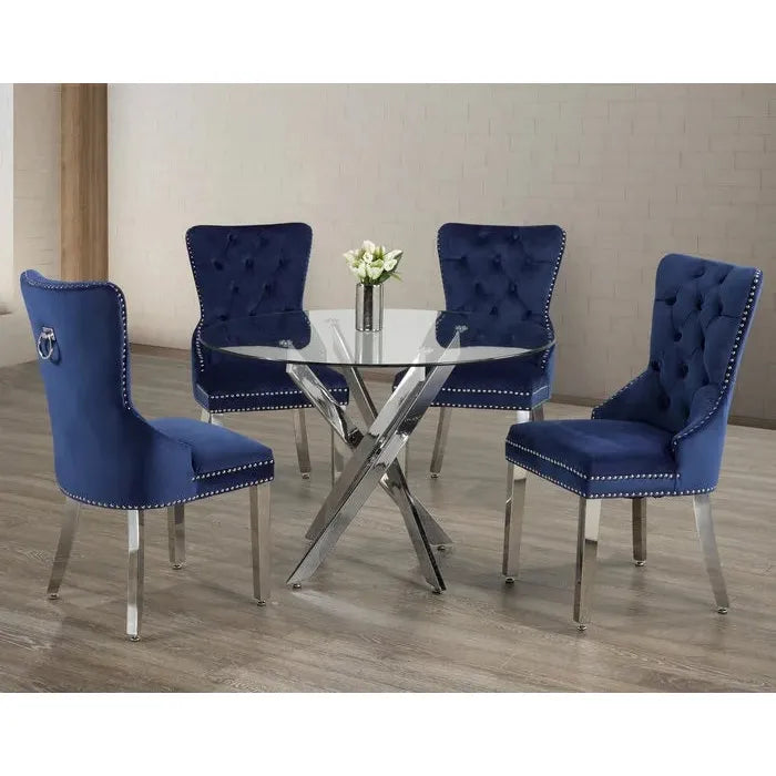 Dining set with four blue tufted chairs with a round glass table.