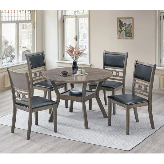 Dining room set with a round wooden table and four chairs with black seats.
