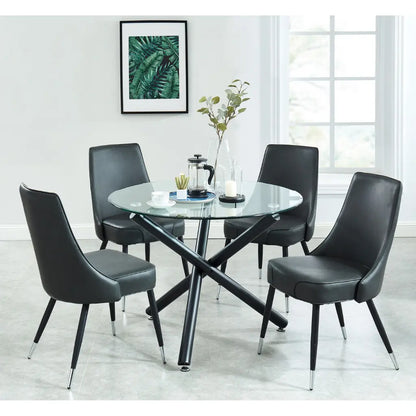 Dining room setup with a round glass table and four black chairs.