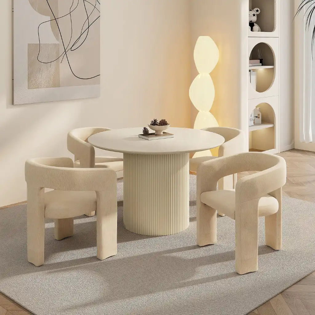 Modern dining room with a round table and four chairs in a stylish interior setting.