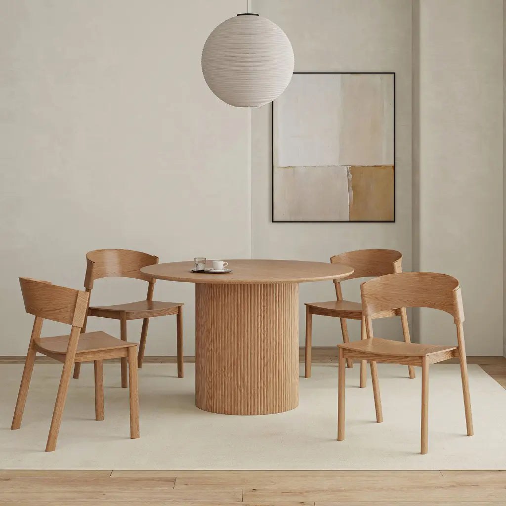 Dining area with wooden table and chairs in a minimalistic room.