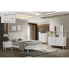 Modern bedroom set with white furniture including bed, nightstands, chest and dresser.
