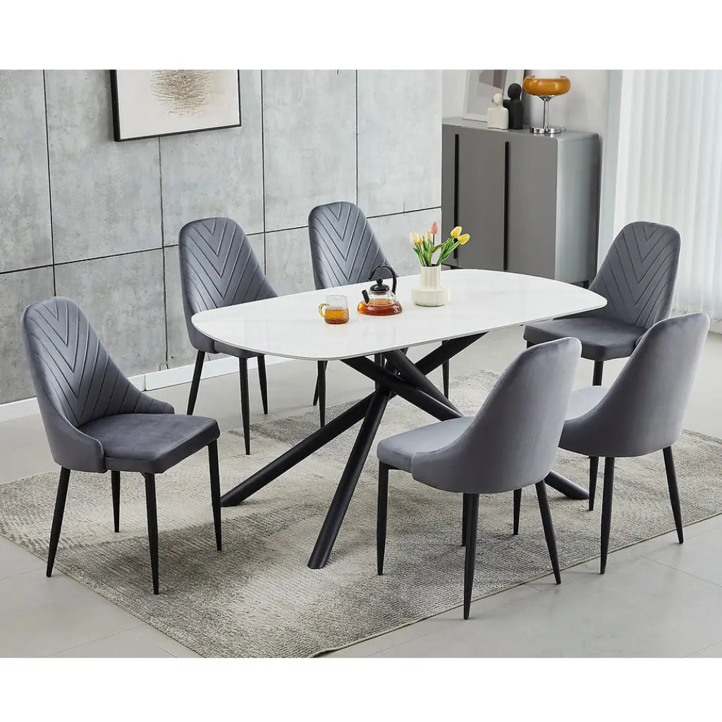 White marble dining table set with six grey velvet chairs 