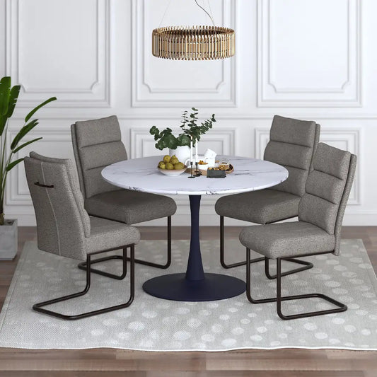 Dining room setup with a round table and four gray chairs in a well-lit room.